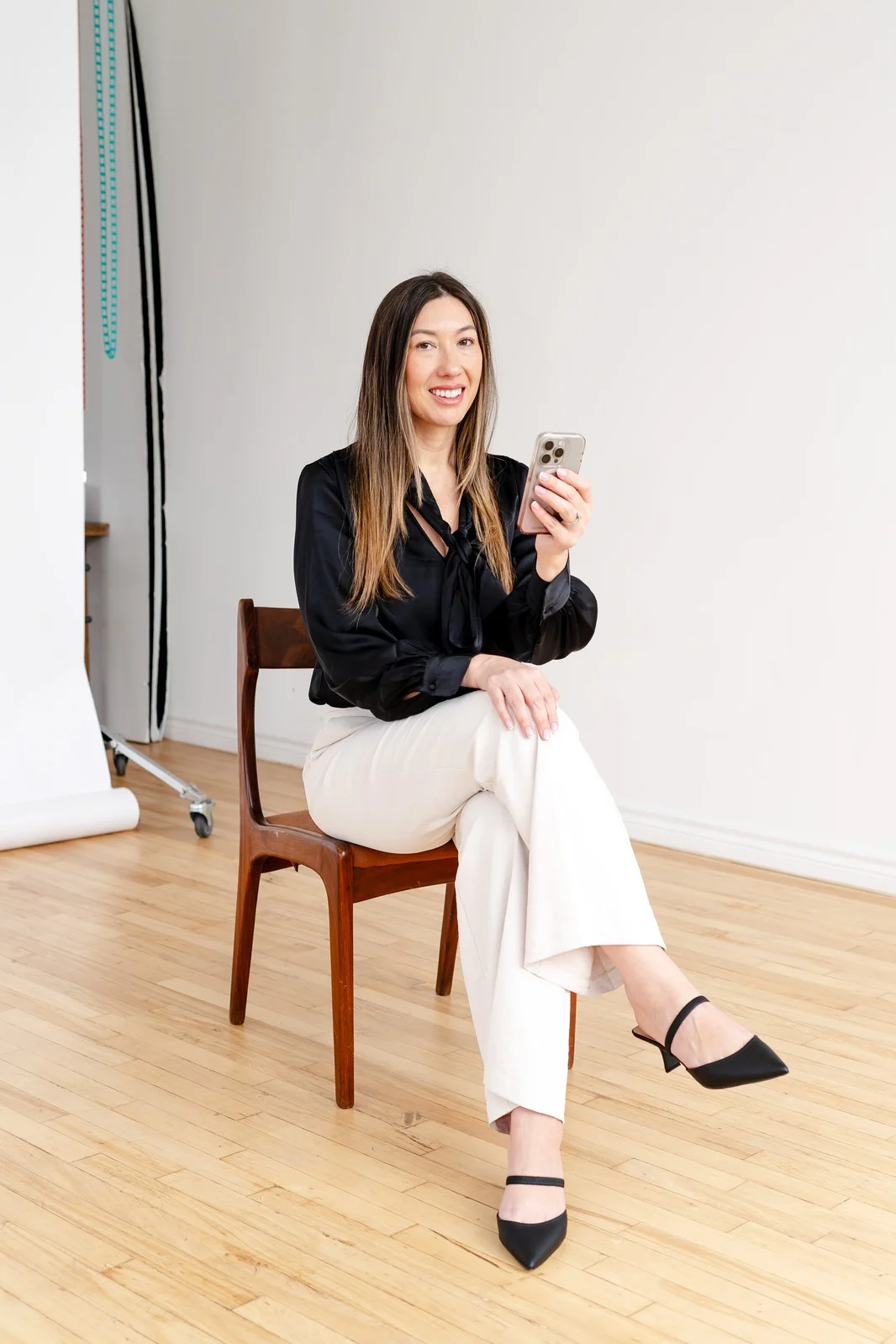 Tamara Nwankwo filming content on her phone in a studio